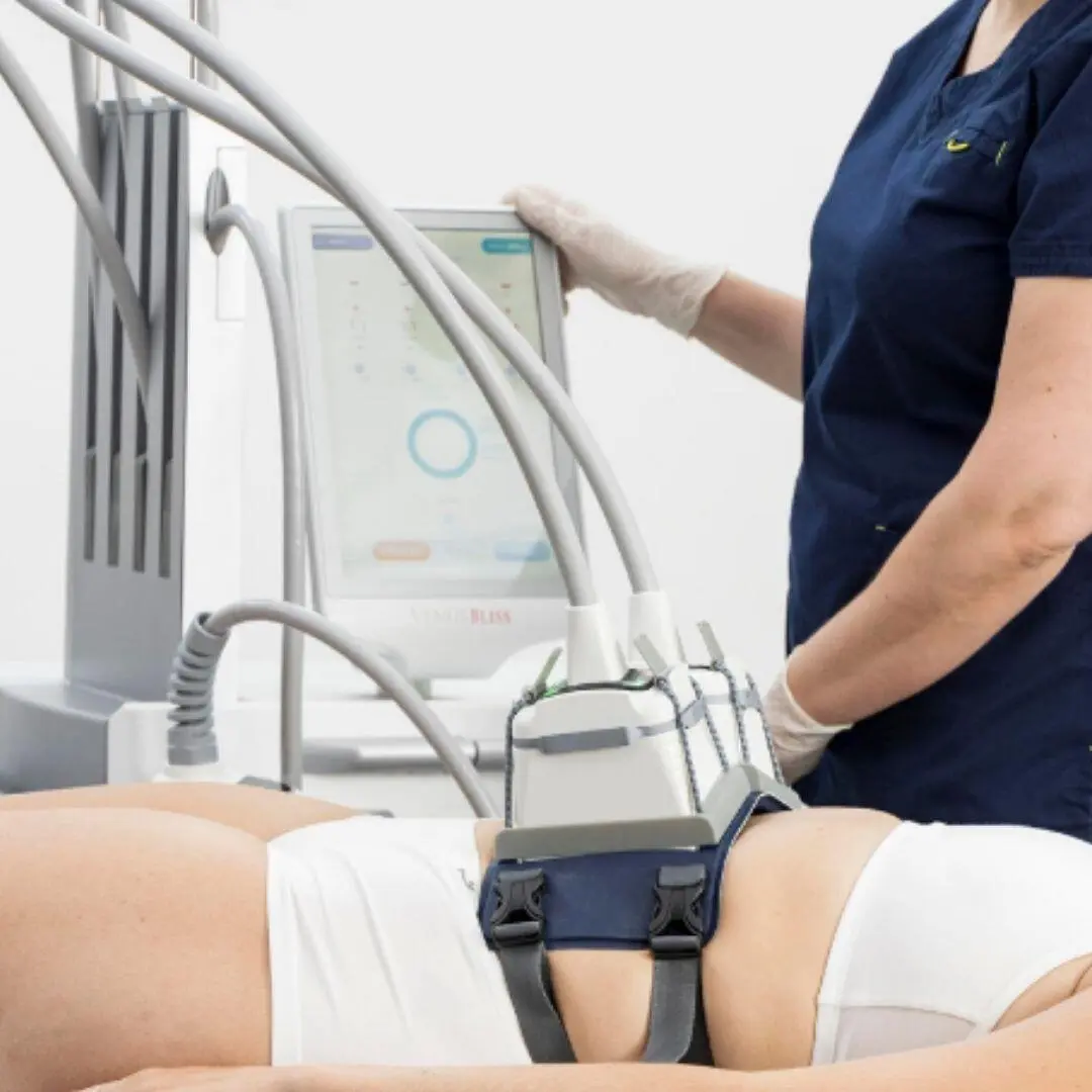 A practitioner operating the Venus Bliss console during a body contouring treatment